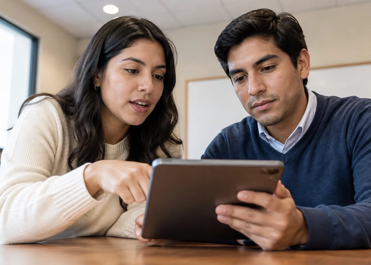 Dos personas inclinadas sobre una tablet con anotaciones